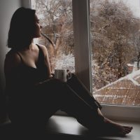 一位年轻女性编辑在双屏前整理分类树结构图，屏幕上是分层的栏目卡片与标签胶囊，环境光柔和